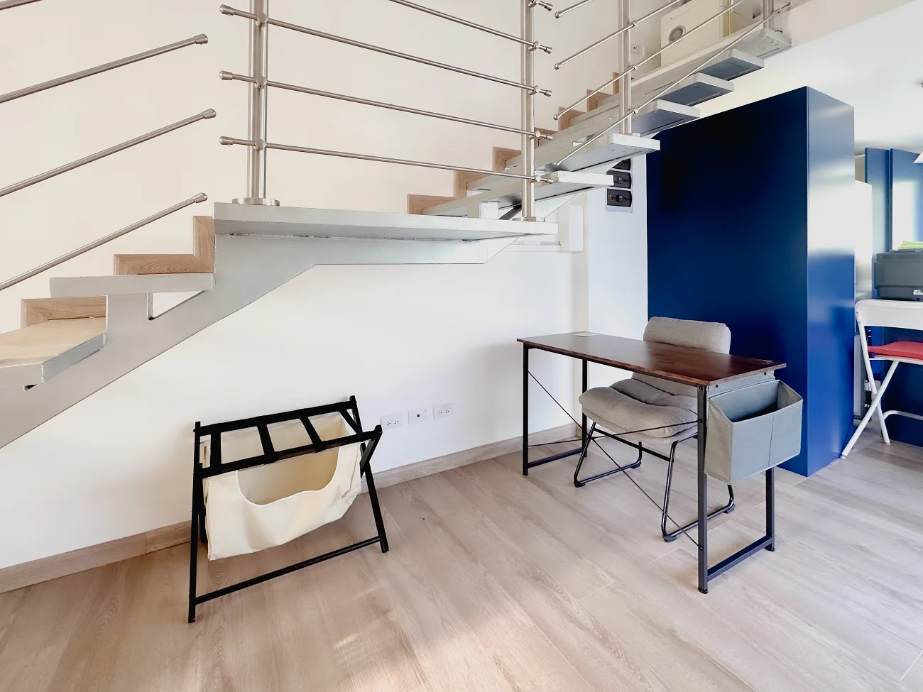 The apartment features the workspace desk and the luggage rack located under the staircase for your convenience.