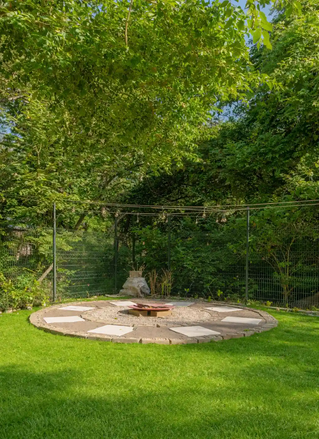 Outdoor fire pit area surrounded by tropical greenery.