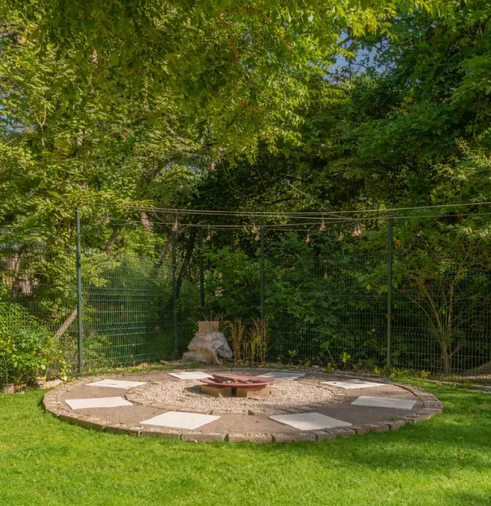 Outdoor fire pit area surrounded by tropical greenery.