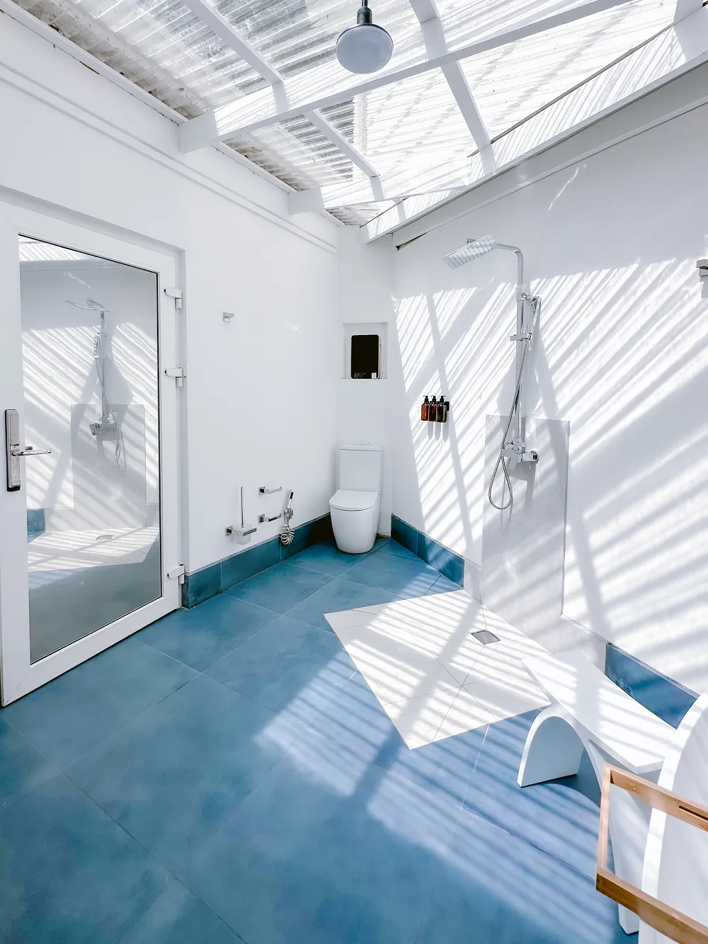 Full bathroom with shower, toilet, blue flooring, and white walls.