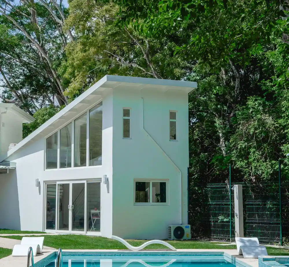 Open windows integrating tropical nature and natural light into a modern design room.