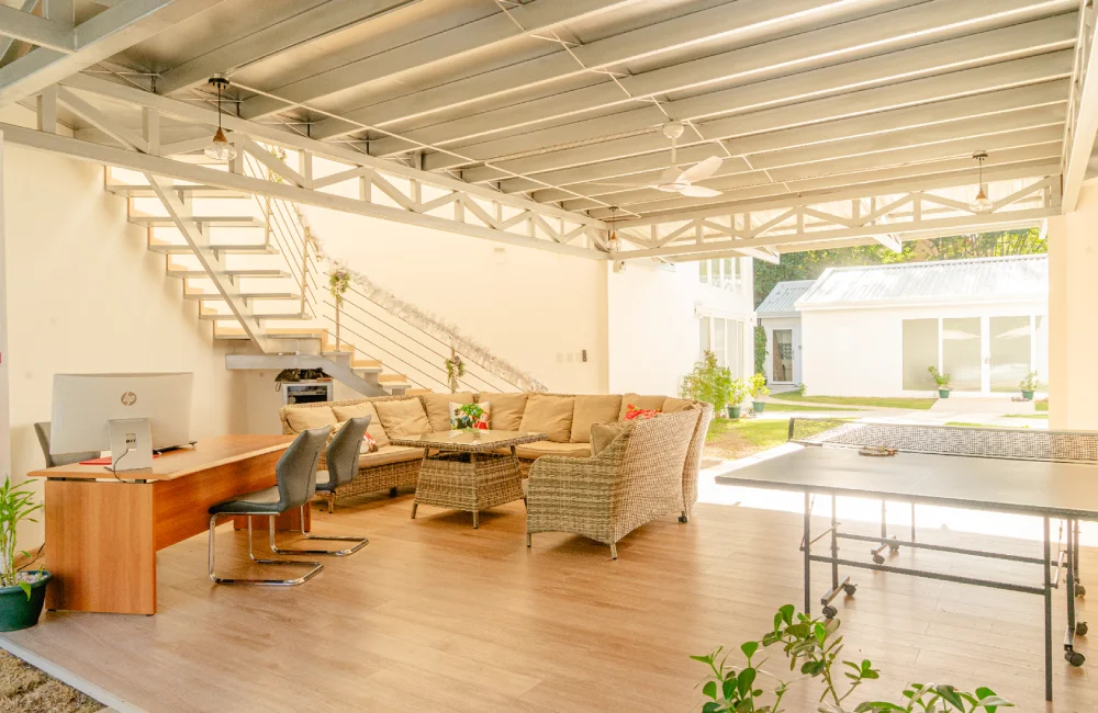 Open reception area featuring a wood desk and lounge seating, with a dedicated ping-pong area.