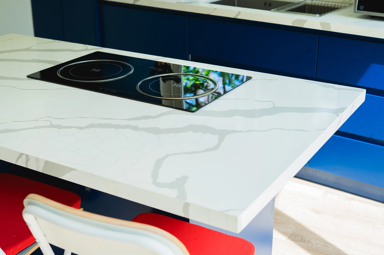 The kitchen is ready to use with the induction stovetop integrated into the quartz island and the breakfast bar space.